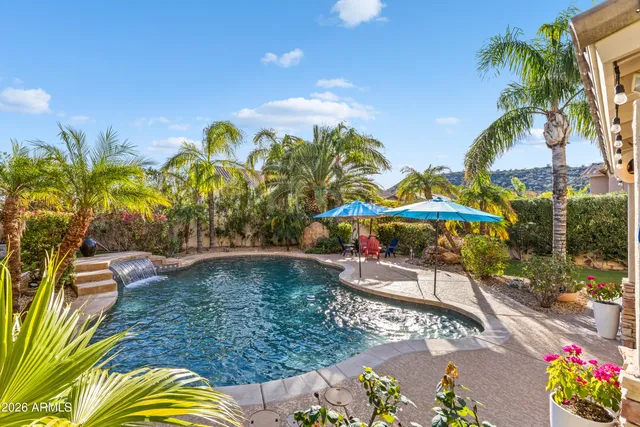 a view of a patio with a table chairs potted plants and water view