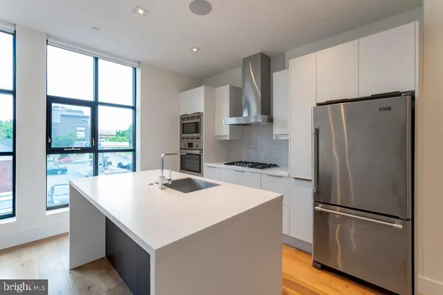 a kitchen with refrigerator cabinets and wooden floor