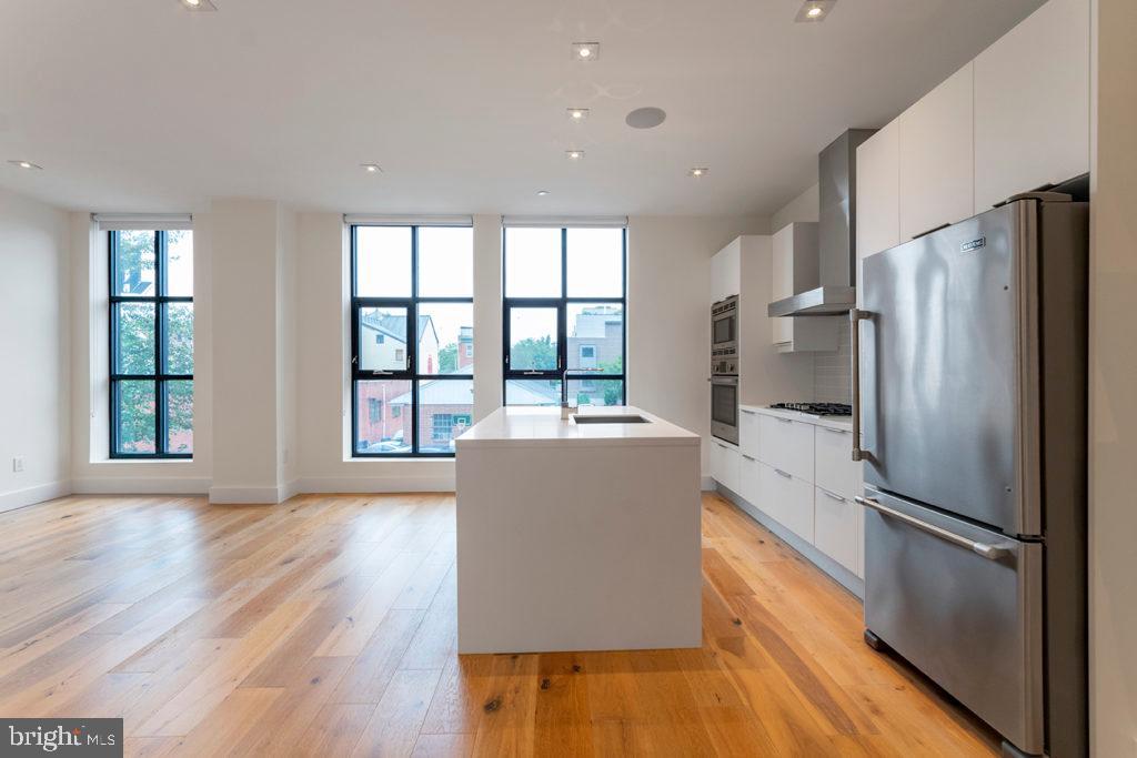 240 North 2nd Street, Unit 2W Philadelphia, PA 19106 - Photo 3 of 13 a kitchen with stainless steel appliances a refrigerator and wooden floor