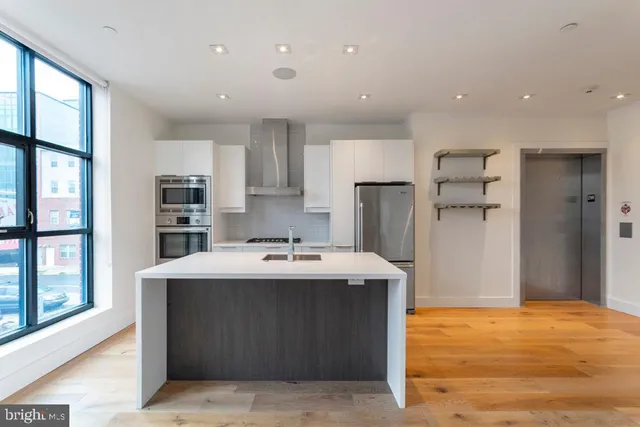 a kitchen with stainless steel appliances a sink stove and refrigerator
