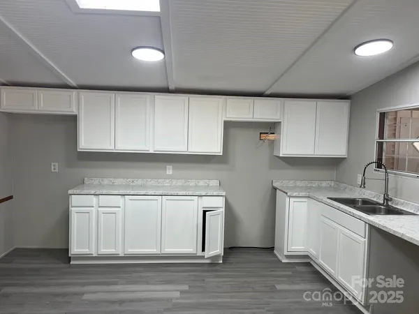a kitchen with a sink cabinets and wooden floor
