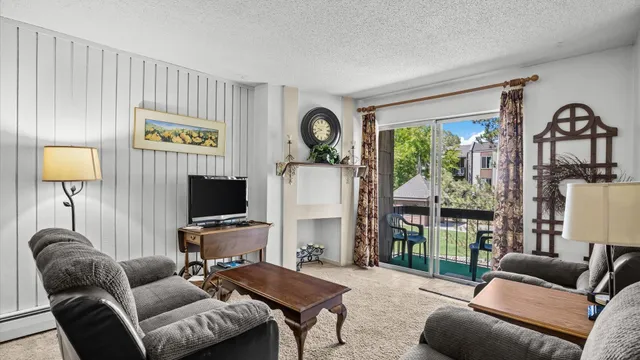a living room with furniture a flat screen tv and a floor to ceiling window