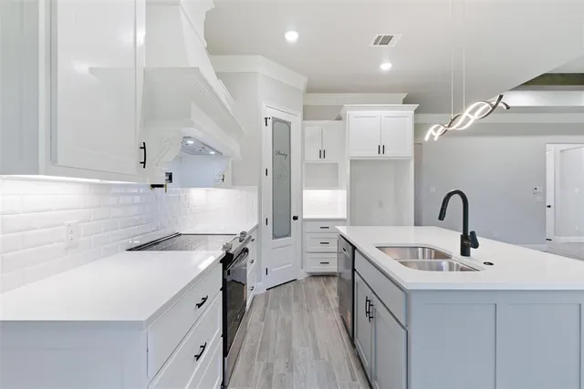a kitchen with sink a stove and cabinets