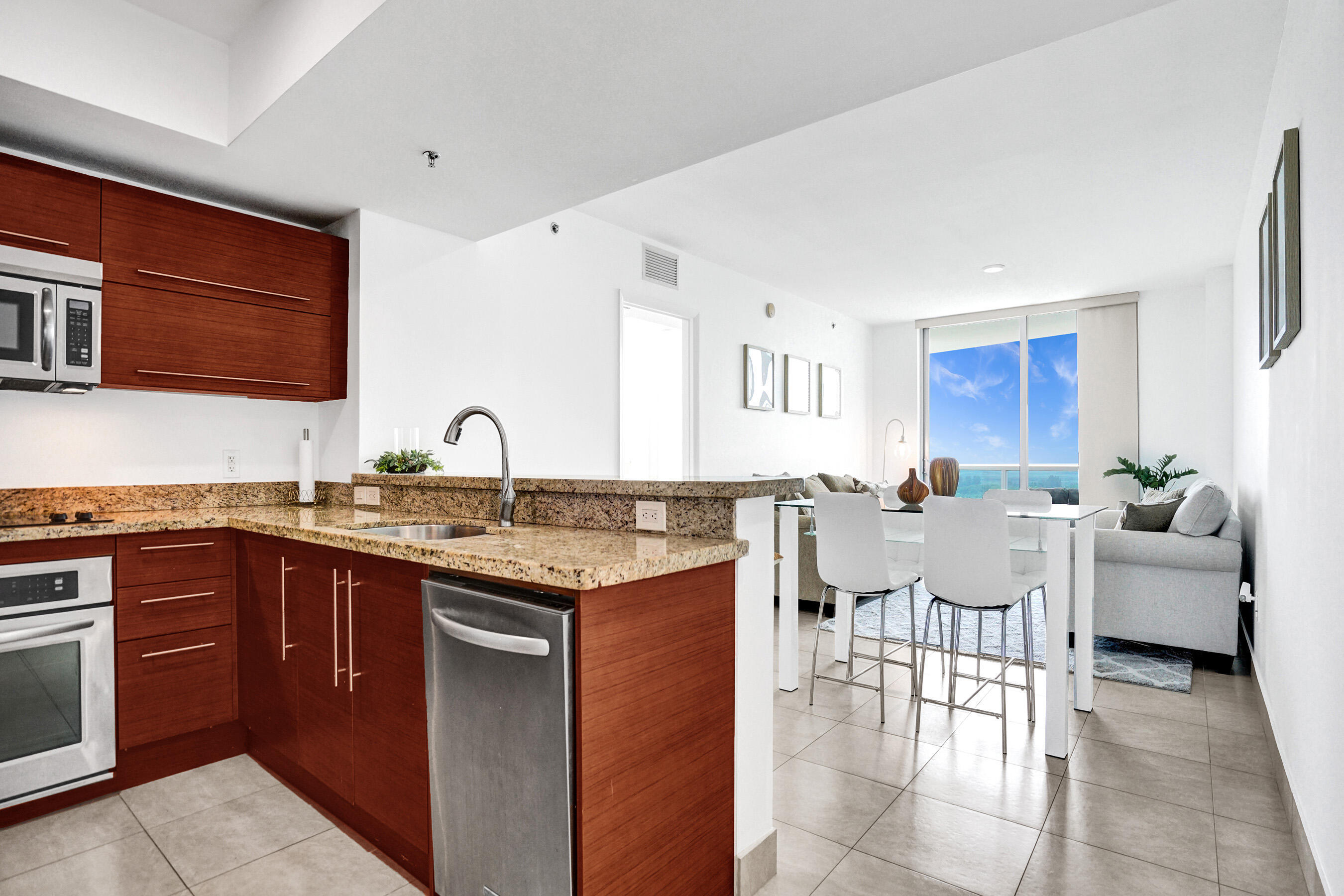2641 North Flamingo Road, Unit 2105N Sunrise, FL 33323 - Photo 13 of 60 a open kitchen with stainless steel appliances granite countertop a sink and dishwasher a stove top oven with wooden floor