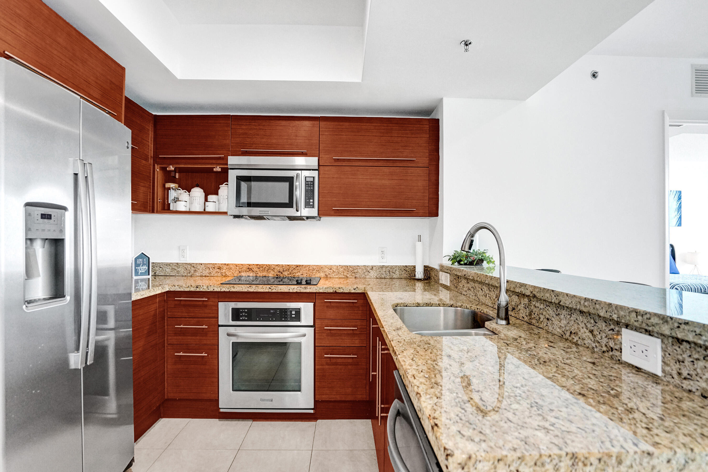 2641 North Flamingo Road, Unit 2105N Sunrise, FL 33323 - Photo 14 of 60 a kitchen with granite countertop a stove top oven microwave and cabinets