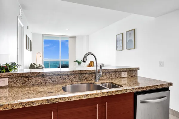 a kitchen with stainless steel appliances granite countertop a sink and a refrigerator