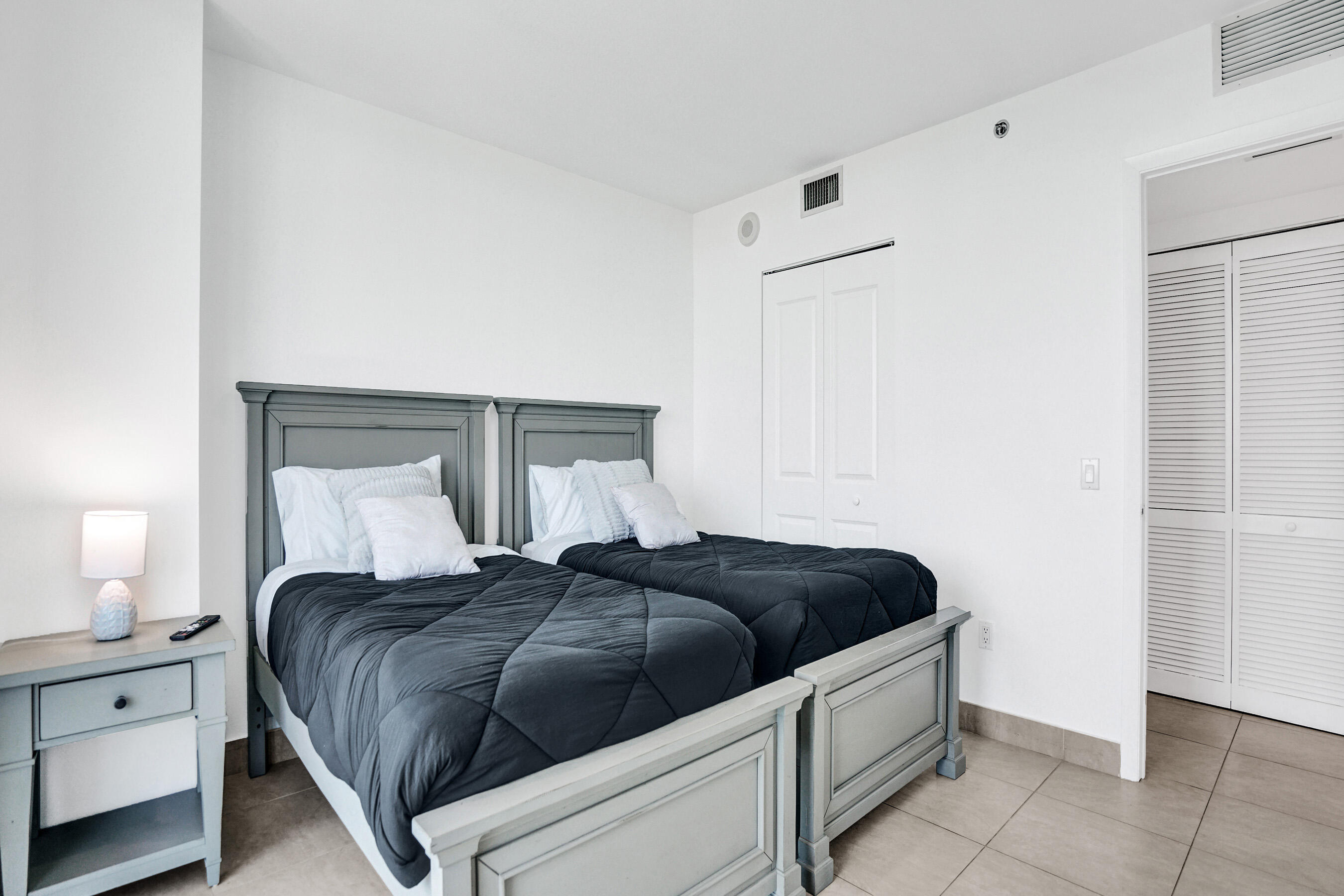 2641 North Flamingo Road, Unit 2105N Sunrise, FL 33323 - Photo 39 of 60 a bedroom with a bed and a lamp on the dresser