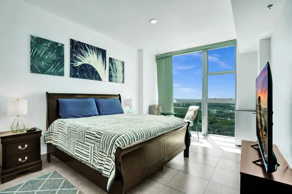 a bedroom with a bed and a flat screen tv