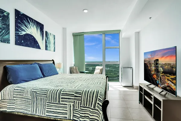 a bedroom with a bed and a flat screen tv