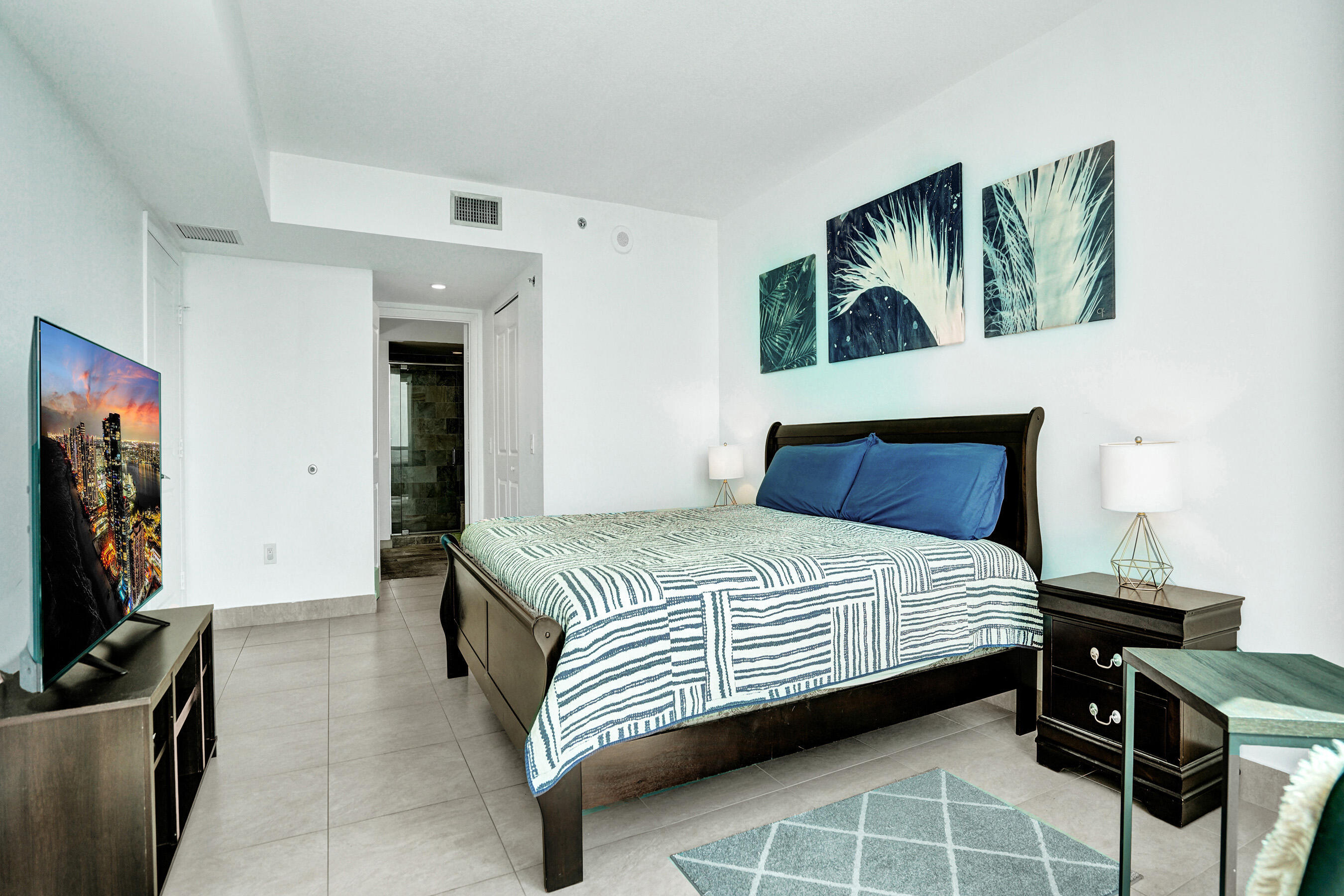 2641 North Flamingo Road, Unit 2105N Sunrise, FL 33323 - Photo 8 of 60 a bedroom with a bed a computer on the desk and a rug