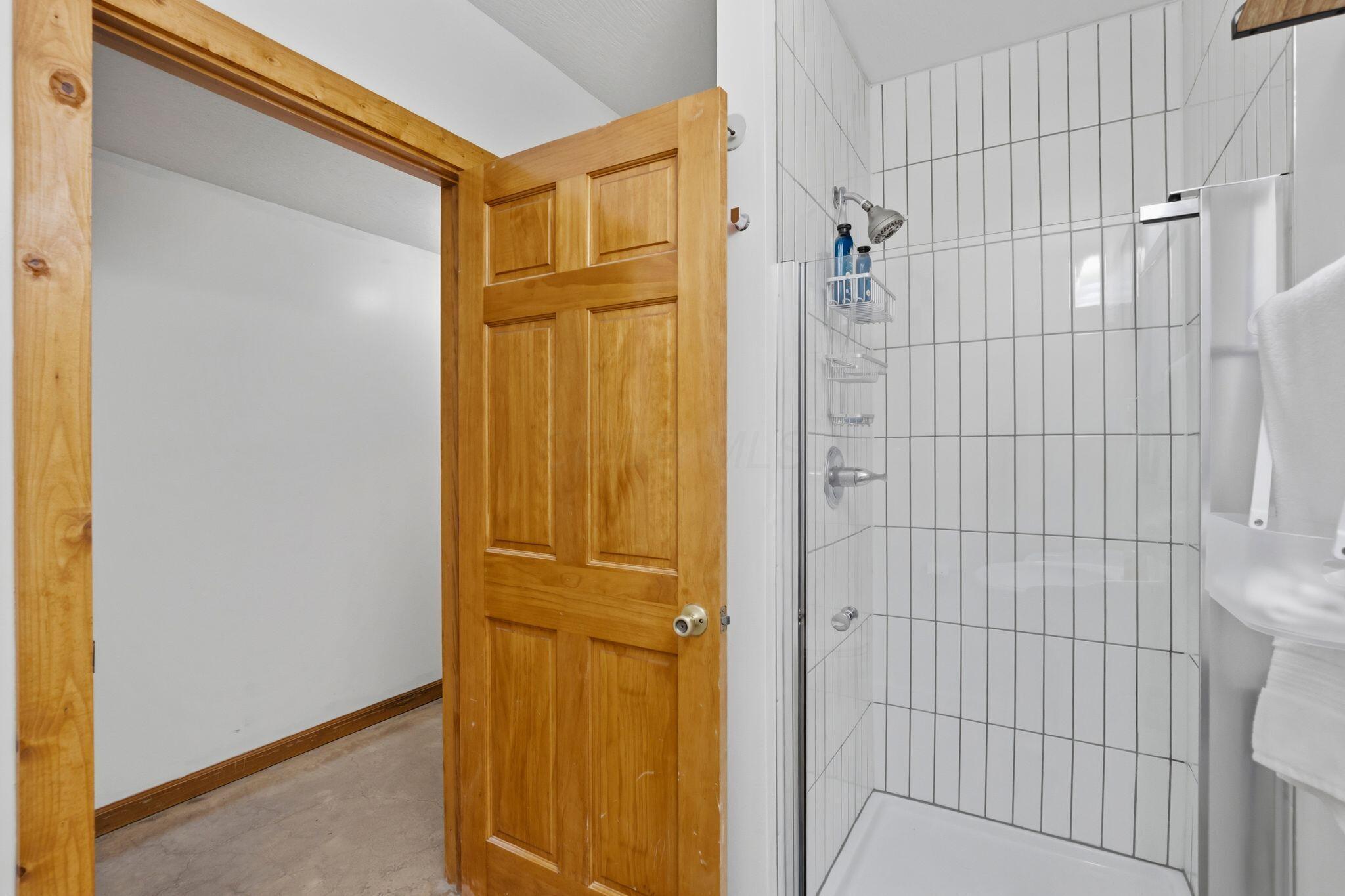 10446 Rich Hollow Road Southwest Lancaster, OH 43130 - Photo 15 of 83 Shower enclosure featuring vertical white subway tile and a clear glass door