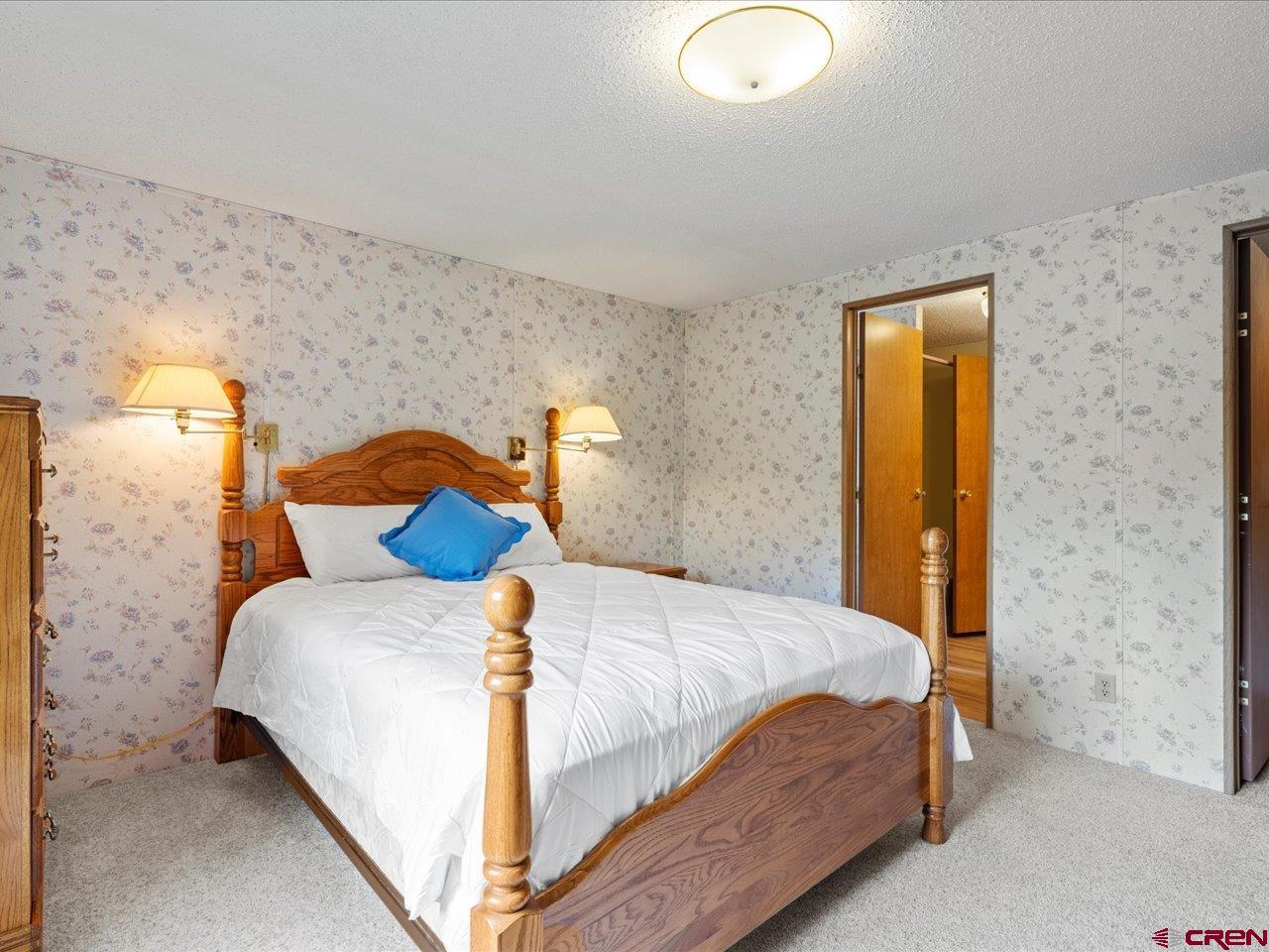 2602 1600th Road Delta, CO 81416 - Photo 12 of 42 a bedroom with a bed and blue wall