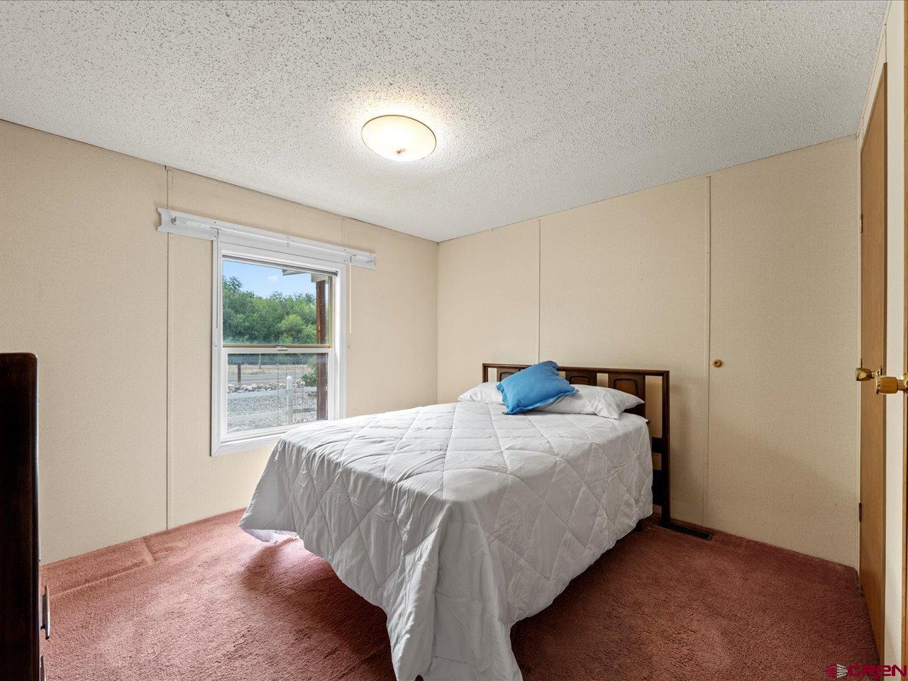 2602 1600th Road Delta, CO 81416 - Photo 27 of 42 a bed sitting in a bedroom next to a window