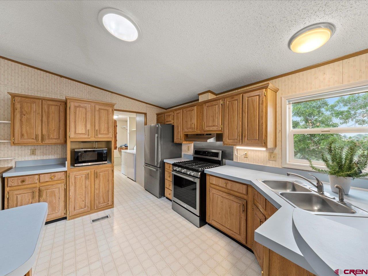 2602 1600th Road Delta, CO 81416 - Photo 9 of 42 a kitchen with granite countertop a stove top oven sink and cabinets