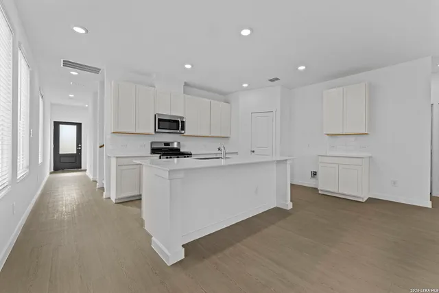 a kitchen with white cabinets and stainless steel appliances