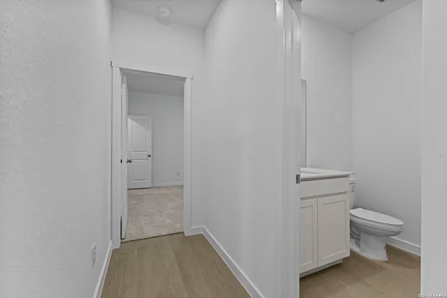 a bathroom with a granite countertop toilet and a sink