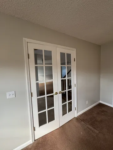 a view of an empty room with wooden floor and closet