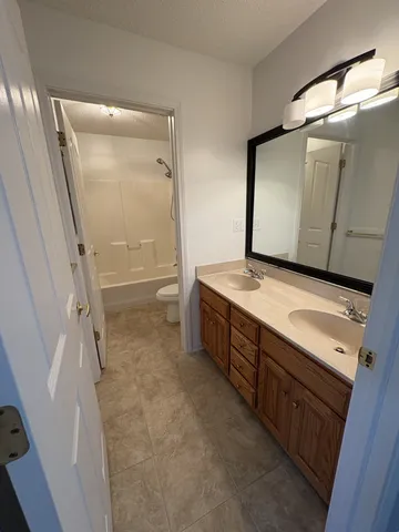 a bathroom with a granite countertop sink a mirror and a bathtub