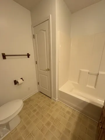 a bathroom with a granite countertop bathtub shower and toilet