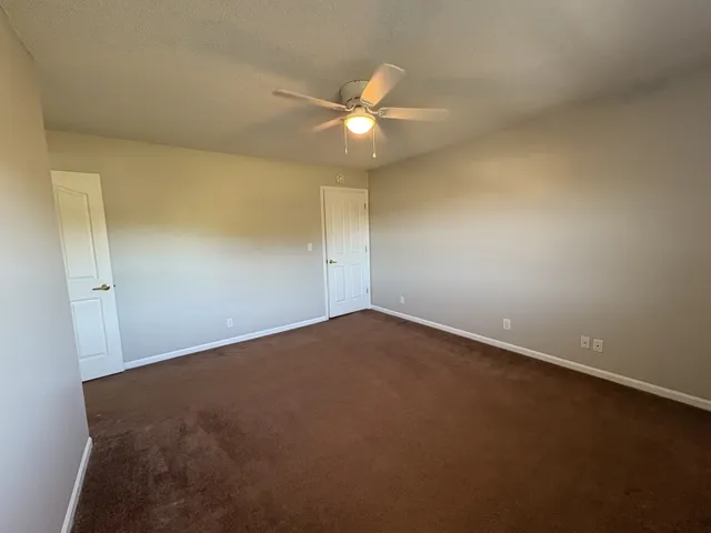 an empty room with a fan and a ceiling fan