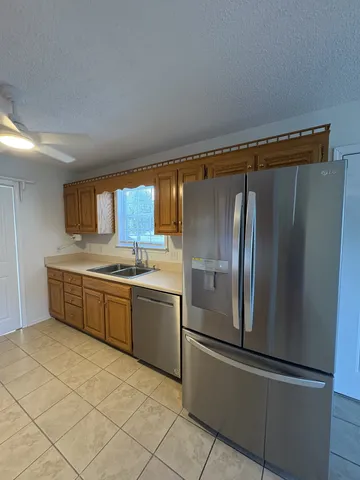 a kitchen with stainless steel appliances granite countertop a refrigerator and a sink
