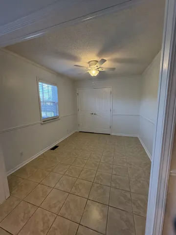 en empty room with windows and fan