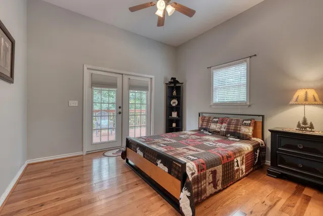 a bedroom with a bed and a chandelier next to a window