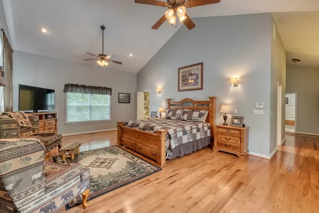 a bedroom with a large bed and a flat tv screen on dresser