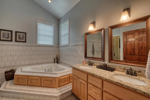 a bathroom with a tub sink and mirror
