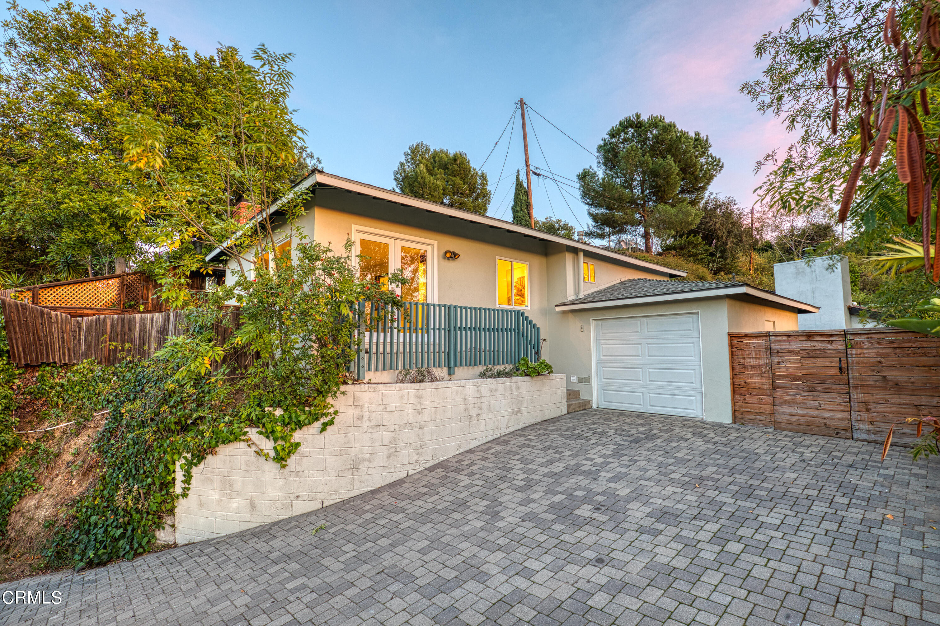 a front view of house with yard and trees in the background