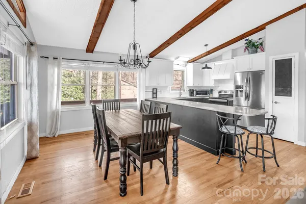 a dining room with furniture a chandelier and wooden floor