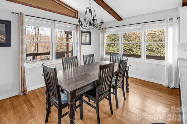 a dining room with furniture a chandelier and wooden floor