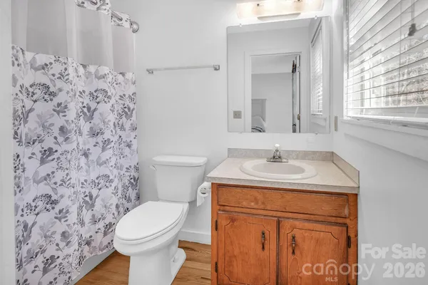 a bathroom with a granite countertop toilet sink and mirror