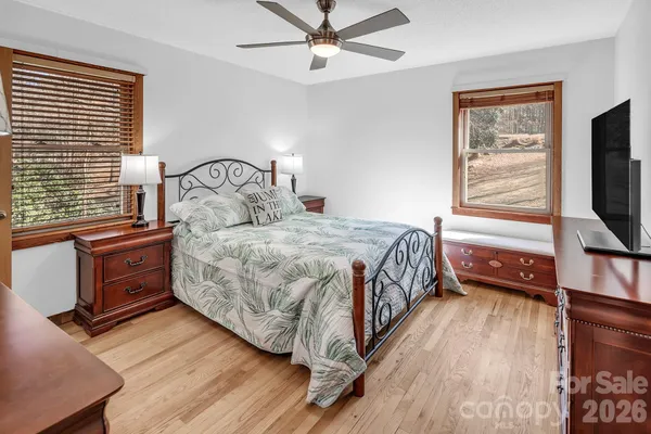 a bedroom with a bed and a flat tv screen on dresser