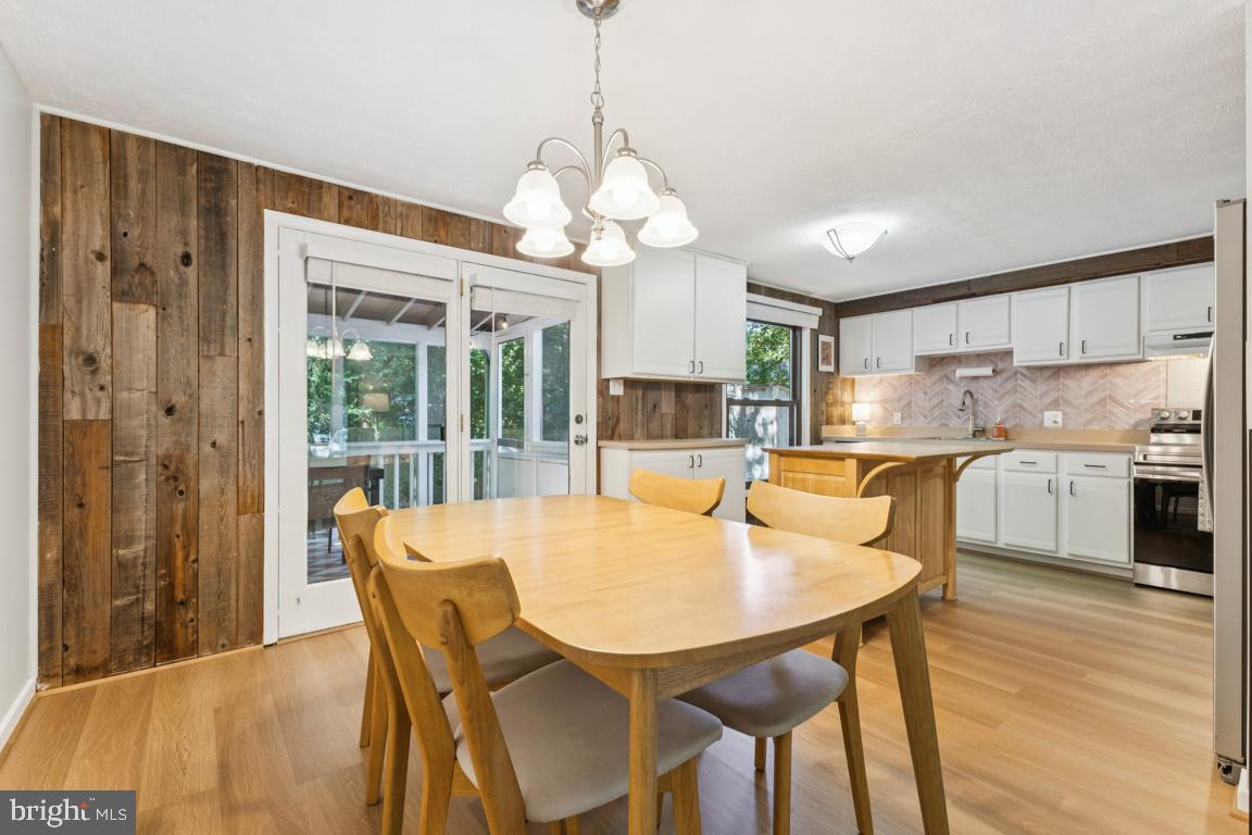2269 Marginella Drive Reston, VA 20191 - Photo 7 of 29 a dining room with wooden floor a chandelier a wooden table and chairs