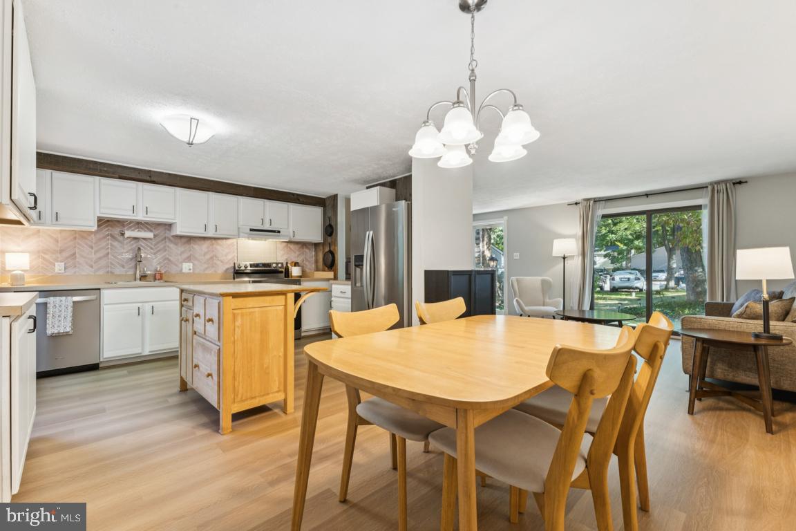 2269 Marginella Drive Reston, VA 20191 - Photo 8 of 29 a kitchen with a dining table chairs sink and white appliances