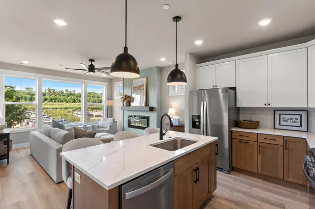 a kitchen with stainless steel appliances granite countertop a sink a stove and a refrigerator