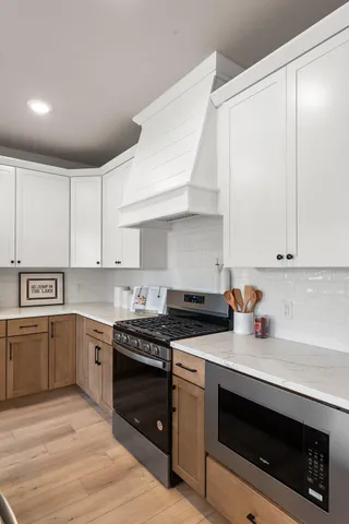 a kitchen with stainless steel appliances granite countertop a stove a sink and a microwave