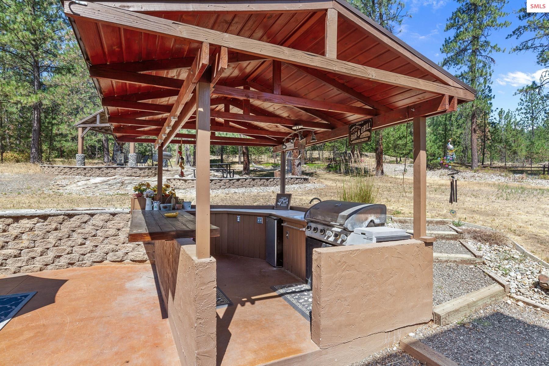 18341 West Highway 53 Rathdrum, ID 83858 - Photo 32 of 41 Kitchen has counter space, cabinets, mini fridge, propane grill and lights.