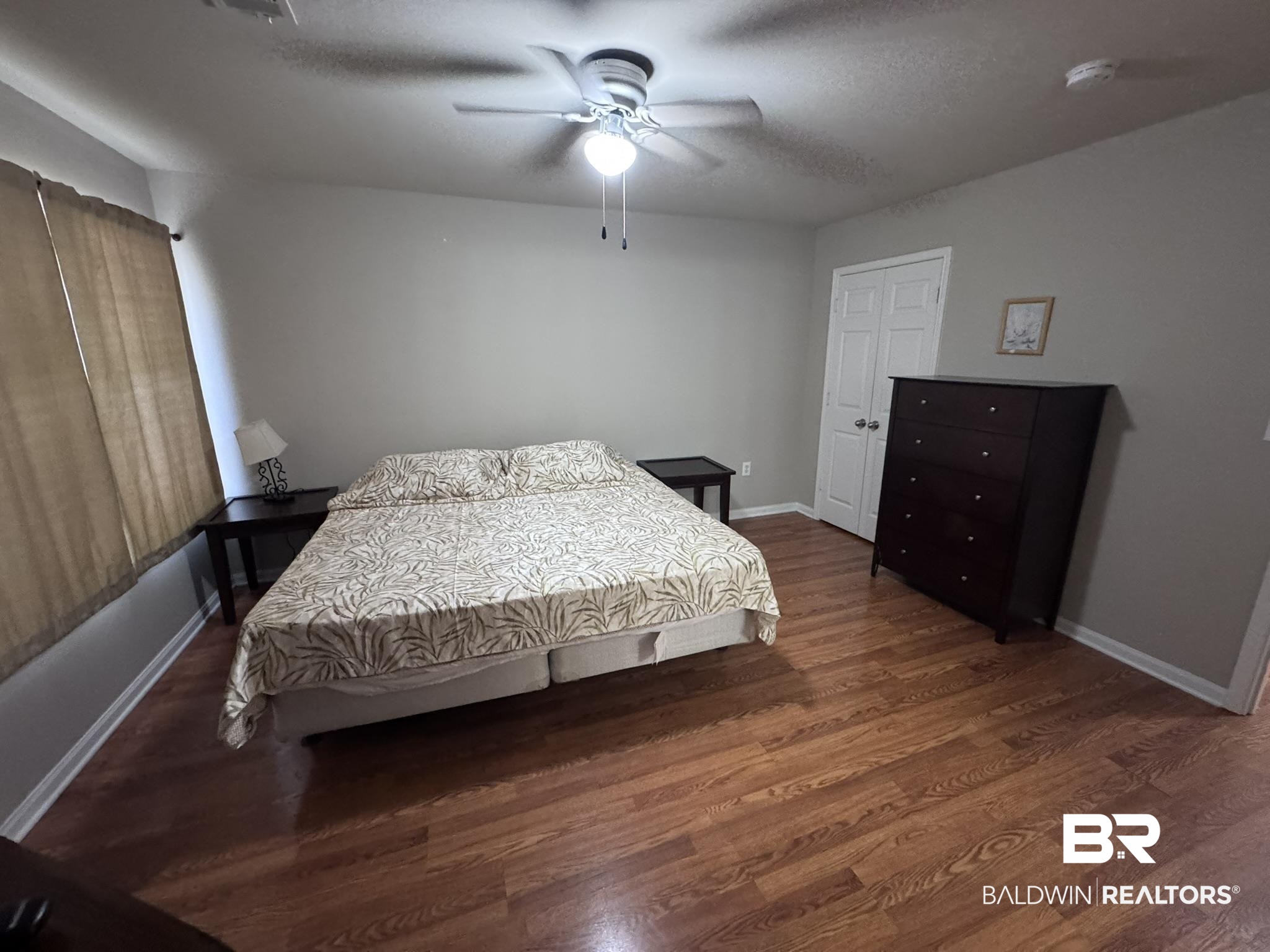 1517 Regency Road, Unit 131 Gulf Shores, AL 36542 - Photo 17 of 21 Bedroom featuring dark wood finished floors, ceiling fan, and a textured ceiling
