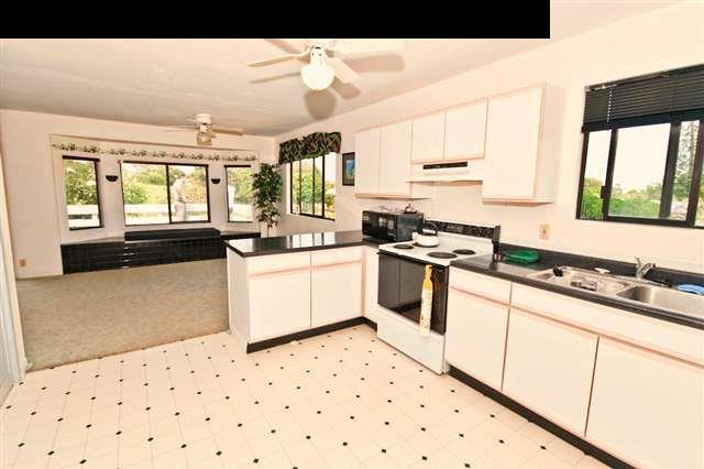 950 Akoa Place Haiku, HI 96708 - Photo 8 of 25 a kitchen with granite countertop a sink a stove a refrigerator and white cabinets