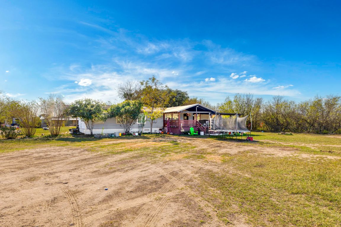 5035 Barth Road Lockhart, TX 78644 - Photo 3 of 40 a front view of a house with a big yard