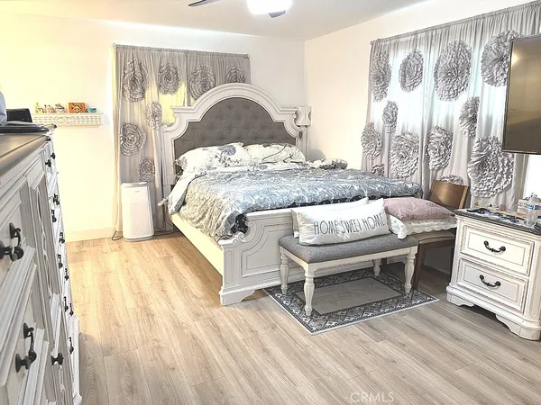 a living room with a bed and a dresser next to a window