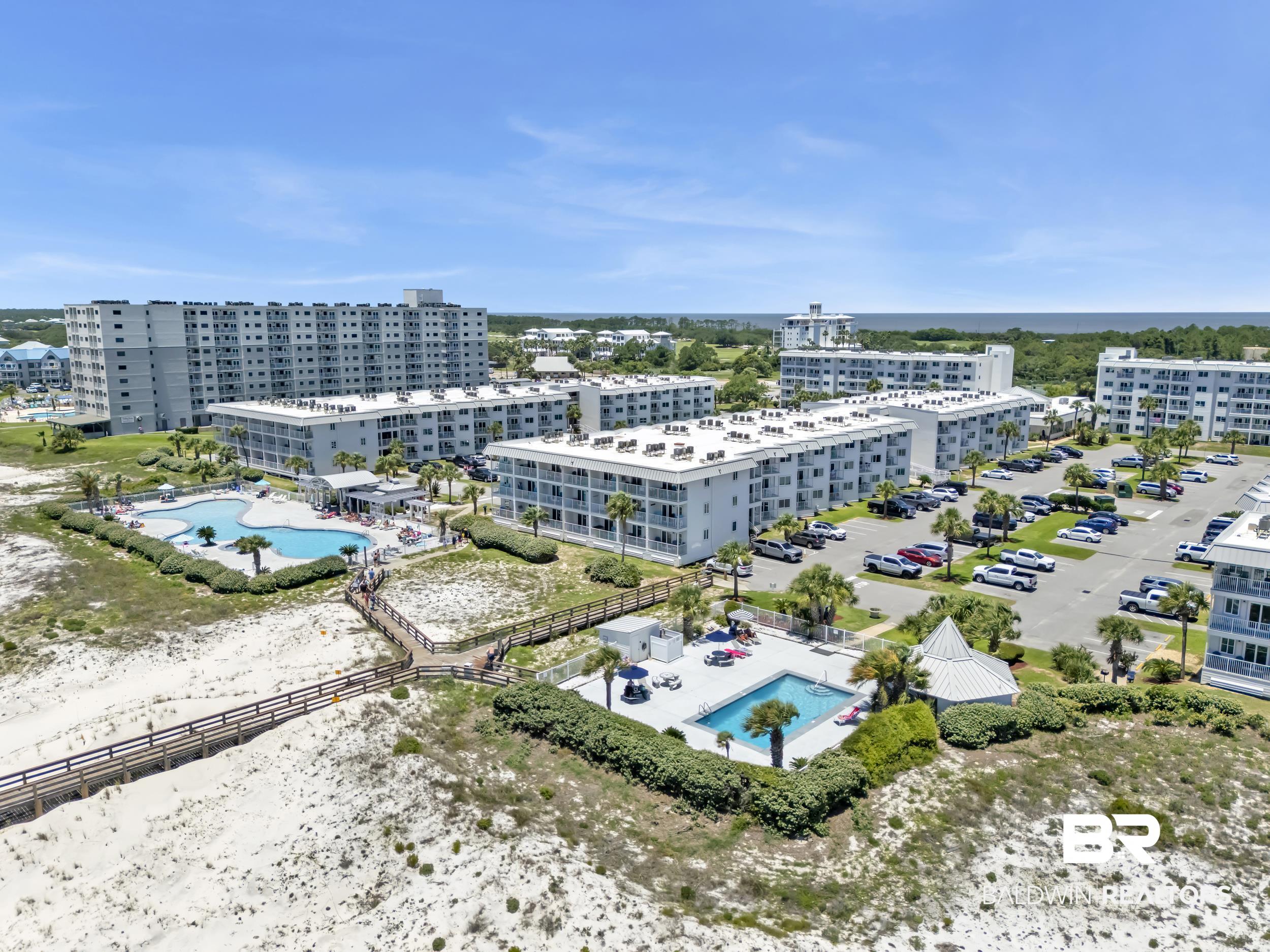 400 Plantation Road, Unit 2118 Gulf Shores, AL 36542 - Photo 48 of 59 Coastal multi-building property featuring multiple swimming pools, extensive parking areas, and a wooden boardwalk system over sandy terrain