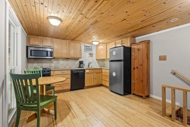 a room with a table chairs wooden floor and a window