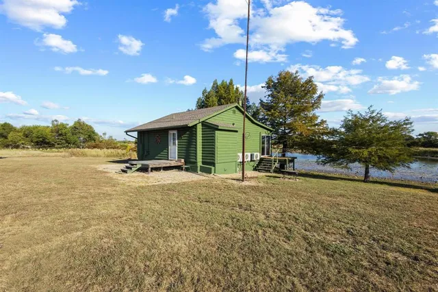 a view of a house with backyard and tree