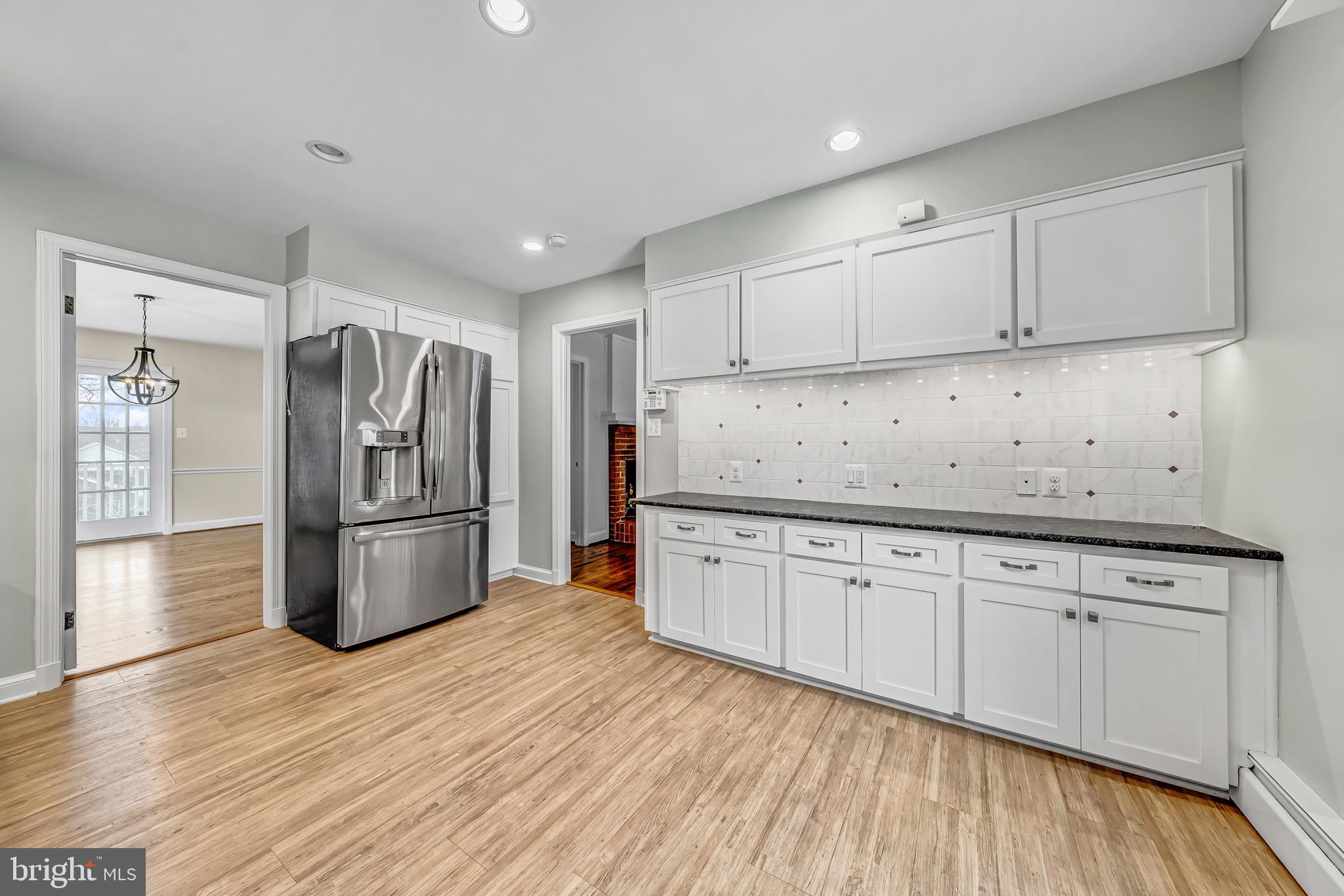17747 Silcott Springs Road Purcellville, VA 20132 - Photo 12 of 42 a kitchen with granite countertop a refrigerator oven a sink dishwasher and white cabinets with wooden floor
