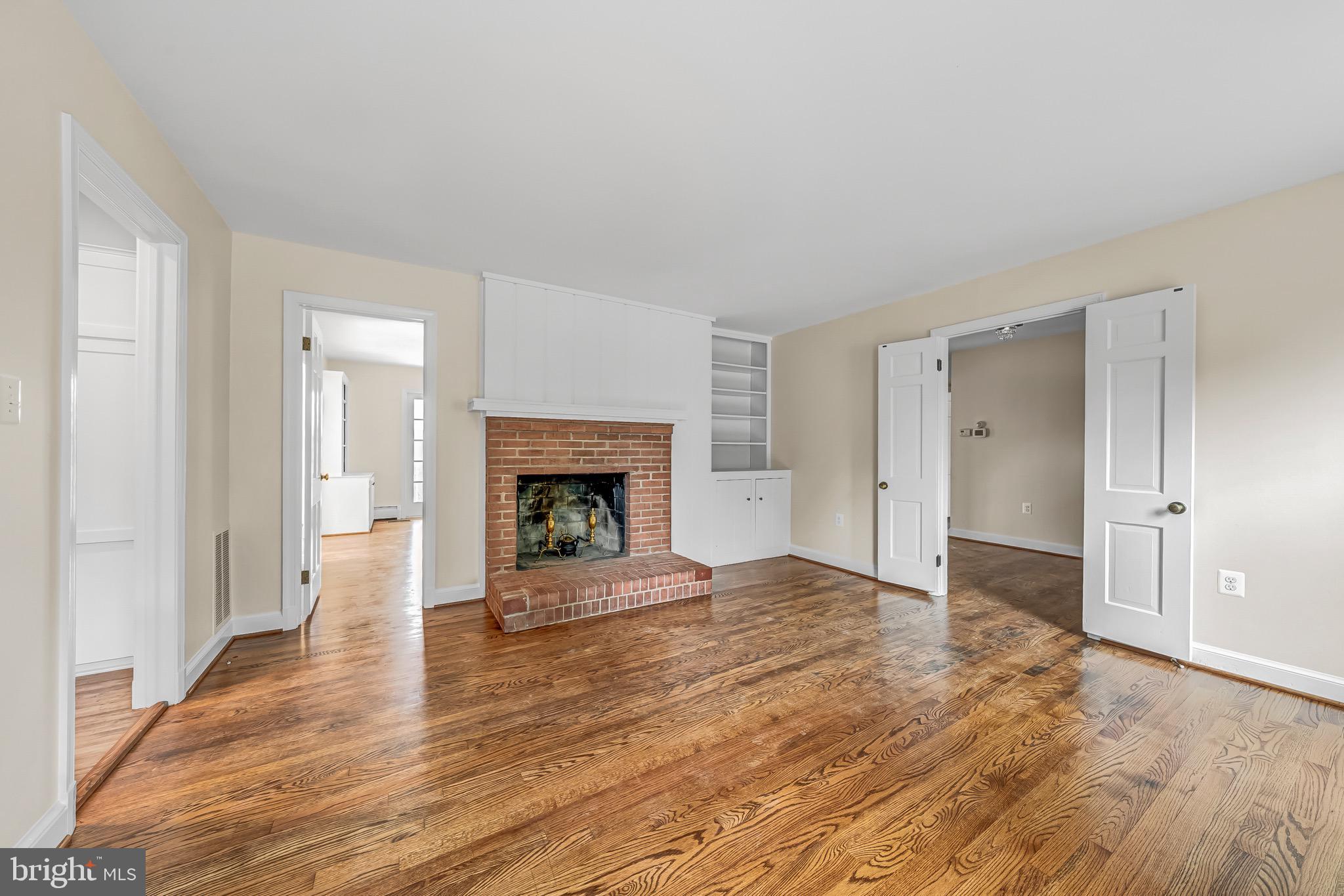 17747 Silcott Springs Road Purcellville, VA 20132 - Photo 17 of 42 a view of an empty room with wooden floor fireplace and a window