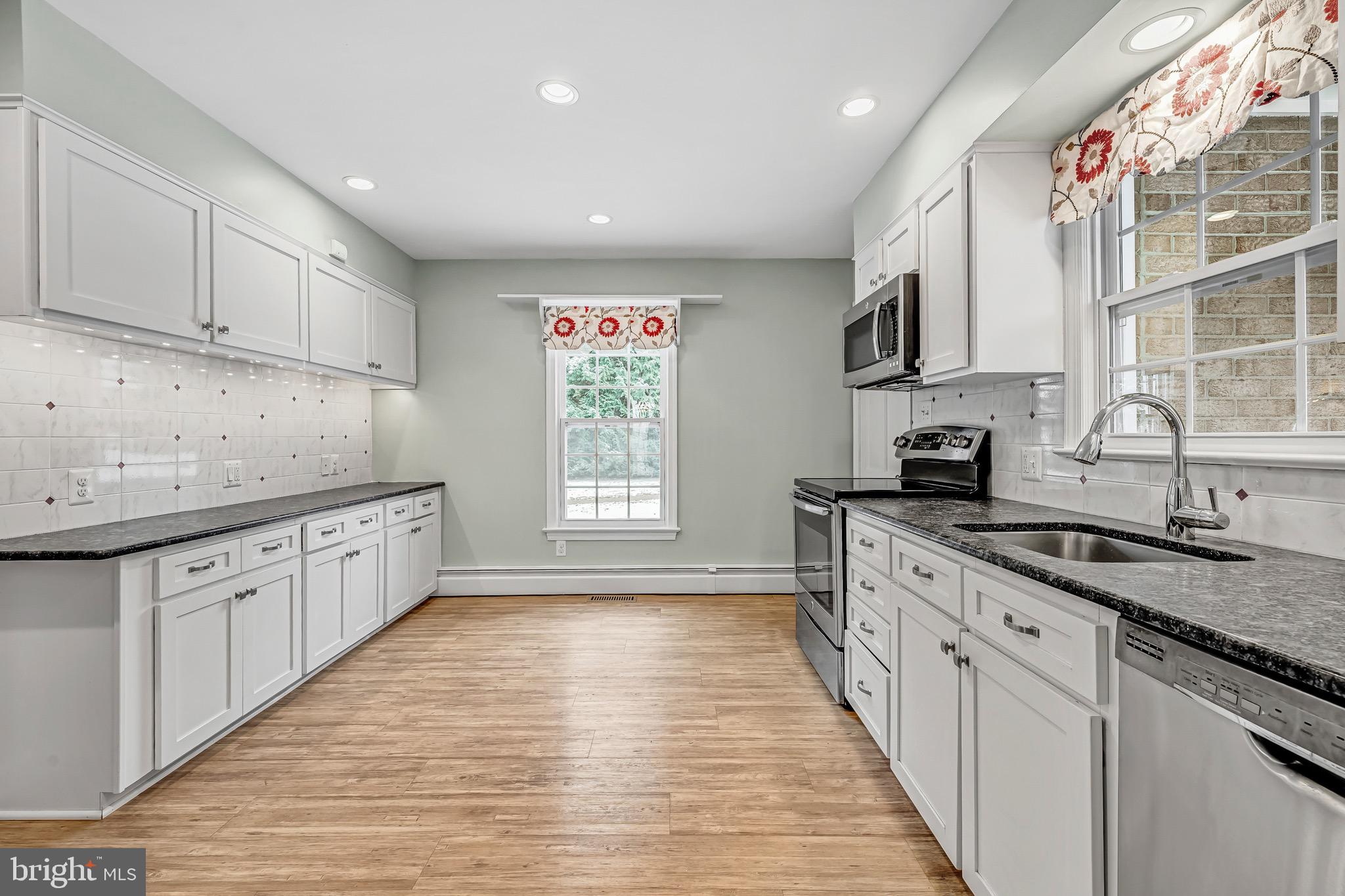 17747 Silcott Springs Road Purcellville, VA 20132 - Photo 9 of 42 a large kitchen with stainless steel appliances granite countertop a sink and cabinets with wooden floor