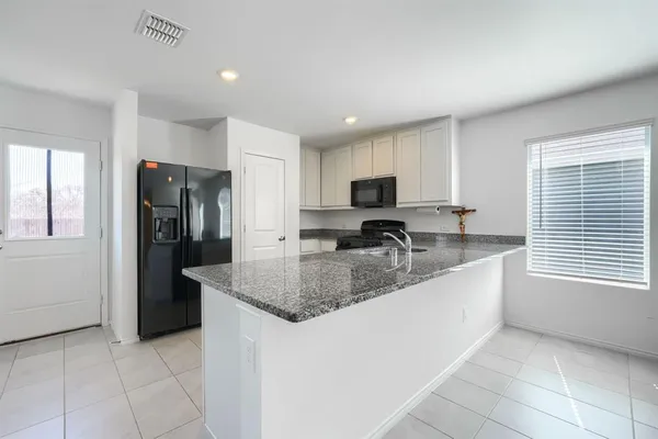 a kitchen with stainless steel appliances granite countertop a sink a stove and a refrigerator